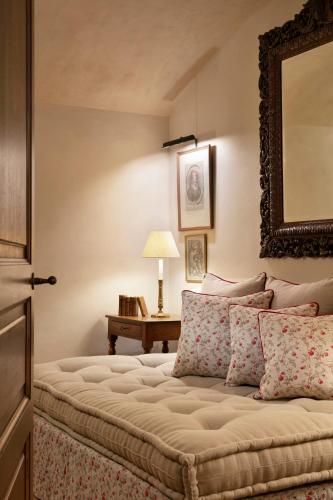 a bedroom with a bed with a mirror on the wall at Airelles Gordes, La Bastide in Gordes