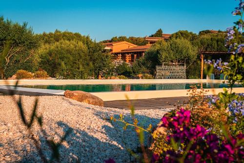 Casagliana Suite Resort في أولبيا: مسبح في ساحة فيها ورد