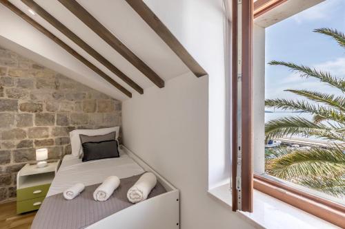 a small bedroom with a bed and a window at D & D Luxury Apartment in Kaštela