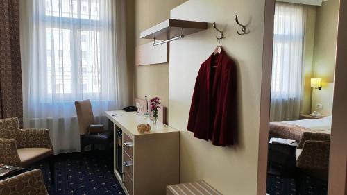 a hotel room with a desk and a bed at Hotel Atlas Halle in Halle an der Saale