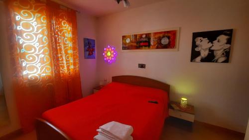 1 dormitorio con 1 cama roja en una habitación en Casa Vacanze Casetta Manila, en Uggiano la Chiesa