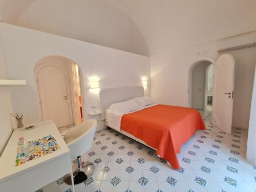 een slaapkamer met een bed, een tafel en een bureau bij Casa Mandara B&B in Positano