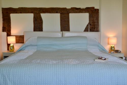 uma cama com um edredão azul e um par de sapatos em Broome Park Farm B&B em Cleobury Mortimer