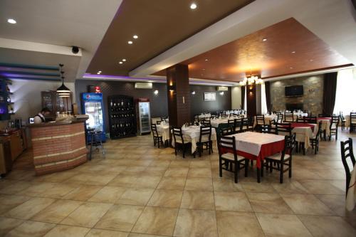 Un comedor con mesas y sillas en un restaurante. en GuestHouse Hamiti Llogara, en Vlorë