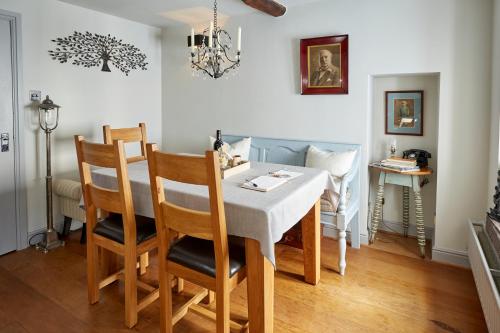 a dining room with a table and chairs at Chapel Cottage Set in a private courtyard in central location with 2 parking spaces in Kirkby Lonsdale