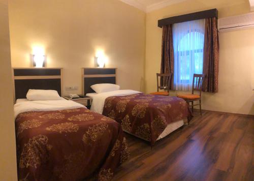 a hotel room with two beds and a window at Hotel Euphrat Nemrut in Karadut