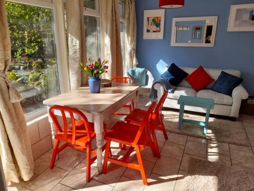 a table and chairs in a living room with a couch at Blue Skies in St Ives
