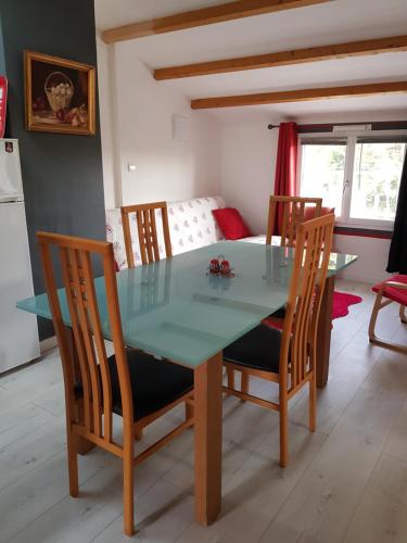 a dining room with a table and chairs and a kitchen at Olékaté in Les Sables-d'Olonne