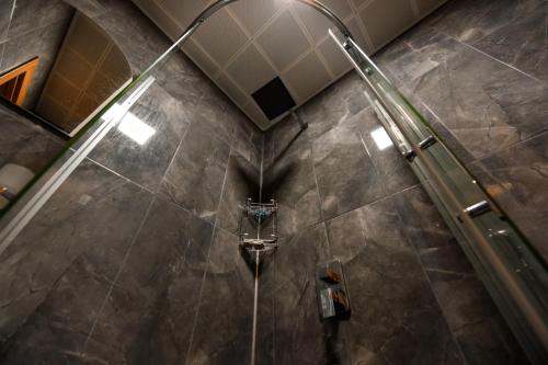a shower in a bathroom with a tiled floor at şerah bungawilla in Uzungöl