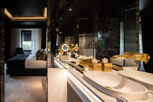a bathroom with two sinks and a bed at Vinha Boutique Hotel - The Leading Hotels of the World in Vila Nova de Gaia
