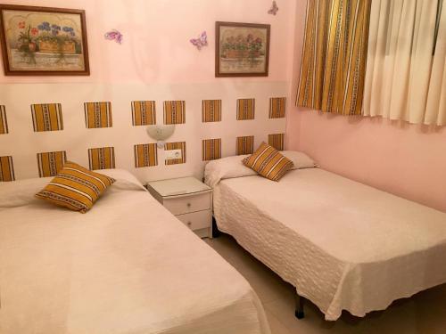 two twin beds in a room with two at Apartamentos Palmavera in Oropesa del Mar