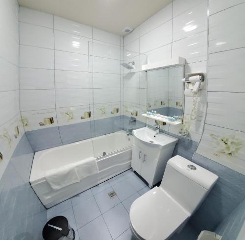 a bathroom with a toilet and a sink and a tub at Hotel Maroqanda in Samarkand