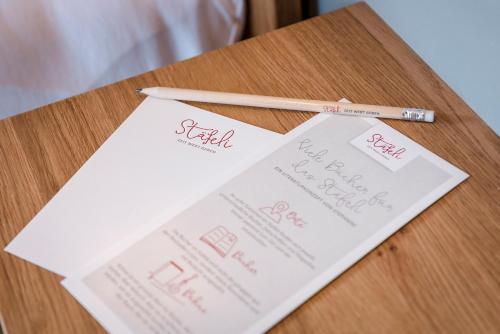 a table with two white papers and a pencil at Hotel Stäfeli in Lech am Arlberg