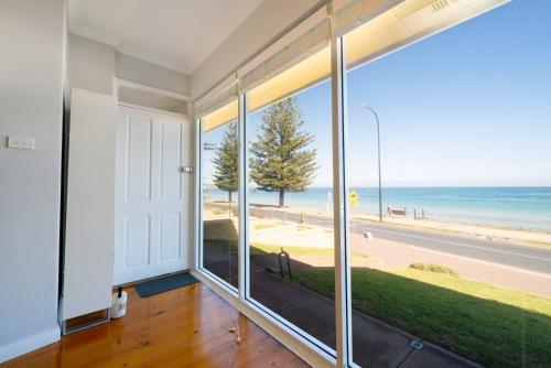 an empty room with a view of the ocean at Brighton Beachfront Sanctuary - Retro Coastal Charm in Brighton