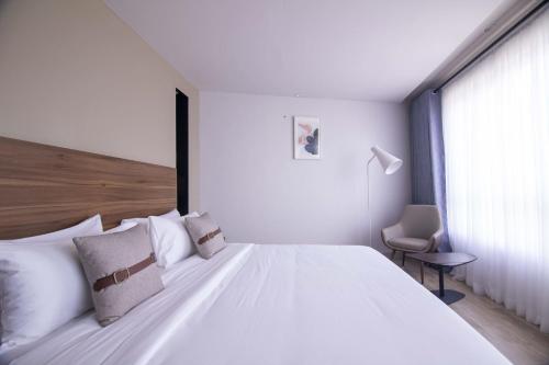 a bedroom with a large white bed and a window at Eseriani The Resort in Naivasha
