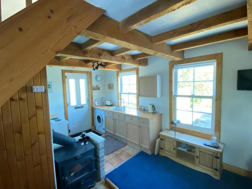 a large kitchen with blue carpet and wooden beams at Lamlash- Self catering accommodation with seaviews in Lamlash