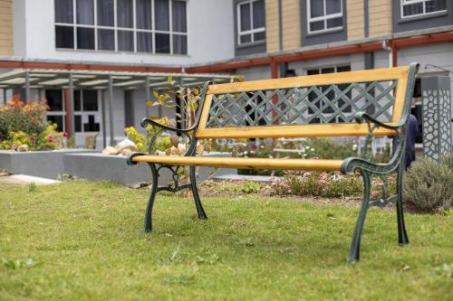 a bench sitting in the grass in front of a building at Eseriani The Resort in Naivasha