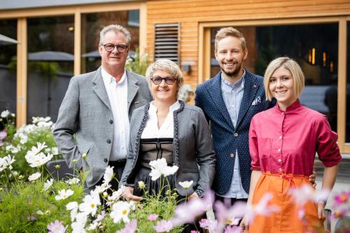 a group of people standing in a garden with flowers at Hotel Stäfeli in Lech am Arlberg
