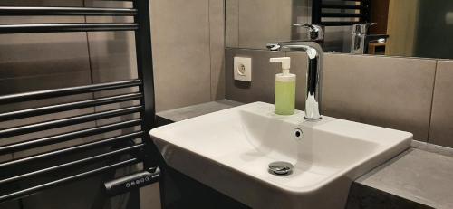 a bathroom sink with a green soap dispenser on it at La Buse in Koekelare
