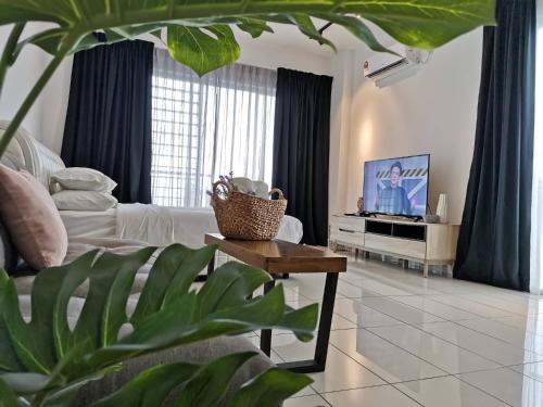 a living room with a couch and a tv at Aeropod Sovo Kota Kinabalu By LAXZONE in Kota Kinabalu