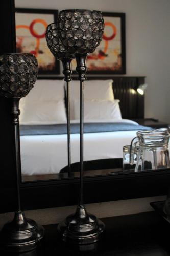 two metal candlesticks in a room with a bed at Nelspruit Lodge in Nelspruit