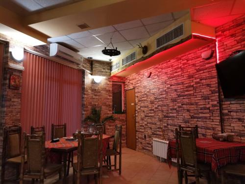 un restaurante con mesas y sillas y una pared de ladrillo en Sveti Georgi Family Hotel en Vŭrshets