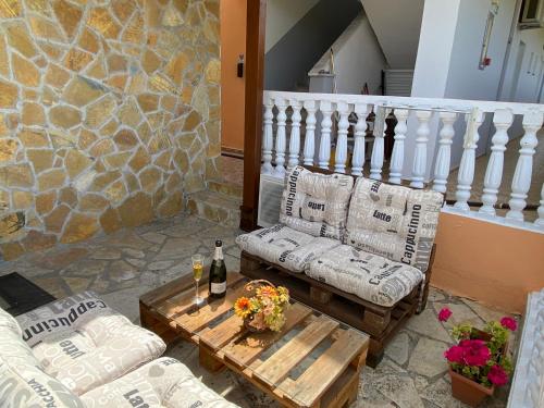 a patio with two couches and a table with a bottle of wine at Daphne Studios in Tsilivi