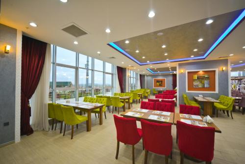 un restaurante con mesas, sillas y ventanas en Ekinci Residence, en Estambul