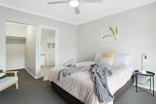 a white bedroom with a bed and a mirror at Milawa Vineyard Views - Guesthouse 1 in Milawa