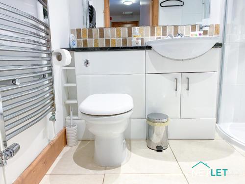 Łazienka z białą toaletą i umywalką w obiekcie Vanguard House, Milford Marina w mieście Milford Haven