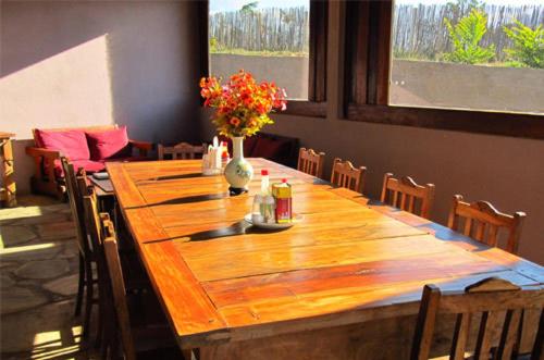 un lungo tavolo di legno con un vaso di fiori sopra di Cataguás Brasil Pousada a Carrancas