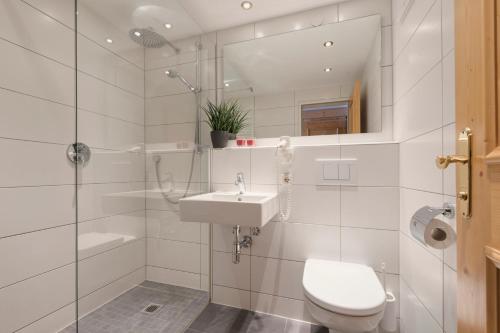 a bathroom with a toilet and a sink and a shower at Hotel Gabl by Alpeffect Hotels in Sankt Anton am Arlberg