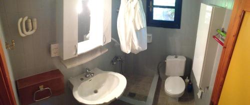 a small bathroom with a sink and a toilet at Secluded 1.8 acre garden Villa, for exclusive use with Stunning Views. in Kalandra
