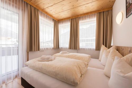 a bedroom with two beds on a white couch at Hotel Gabl by Alpeffect Hotels in Sankt Anton am Arlberg