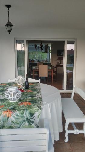 a dining room with a white table and a white chair at Quinta do Soldado in Albergaria-a-Velha