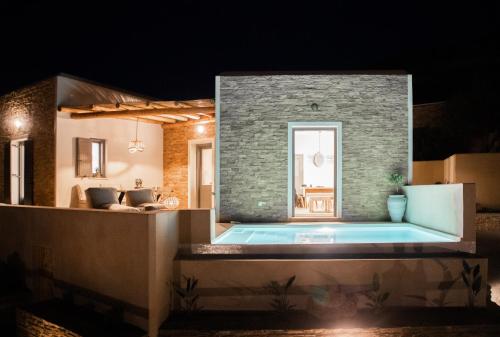 a house with a swimming pool at night at Youtopia Ios Villas in Ios Chora