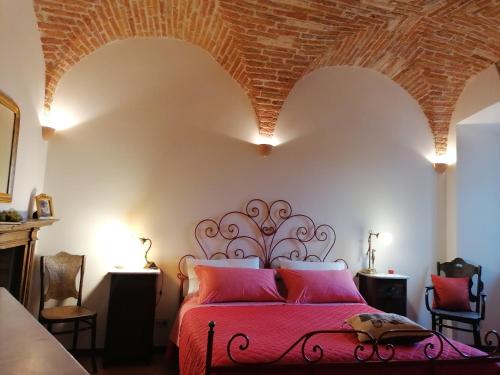 a bedroom with a red bed with a brick ceiling at Residenza Le Peonie in Todi