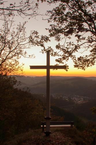 a cross on top of a hill with a bench at Landgasthof Zur Erholung in Breitscheid