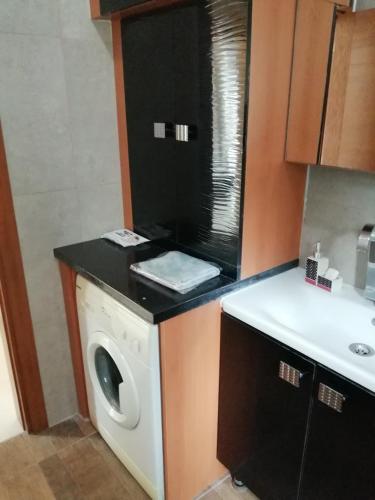 a kitchen with a washing machine and a sink at Aqua Royal Alexus Luxury Holiday Apartments Girne in Kérynia