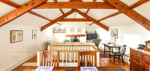 a kitchen and living room with wooden beams at Ballavere Cottage B&B in Colby