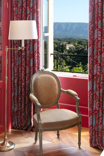 a chair sitting in a room with a window at Airelles Gordes, La Bastide in Gordes