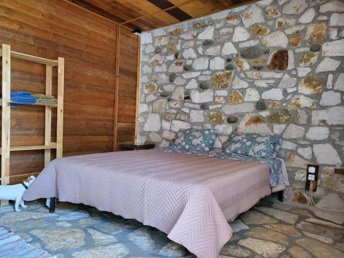 una camera da letto con un muro in pietra con un letto di Filoxenia - The Place of Experience a Himare