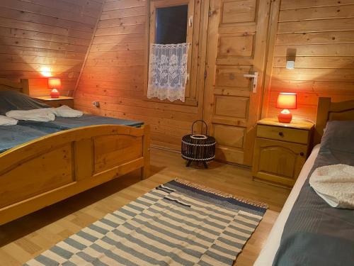 a bedroom with two beds in a wooden cabin at Sikaszoi vizimalom in Sicasău