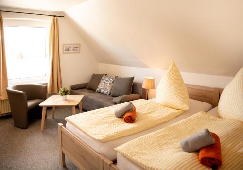 sala de estar con 2 camas y sofá en Landgasthof Nüchel en Malente