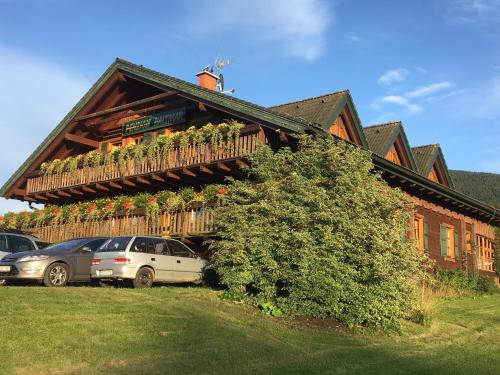 a house with cars parked in front of it at Penzion Haltmar in Ostružná