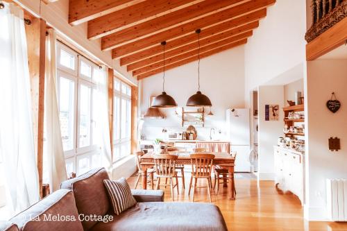 a kitchen and living room with a table and chairs at La Melosa Cottage in Cudillero