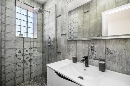 bagno con lavandino bianco e doccia di Maredimo Village Porto Casa 2 a Porto