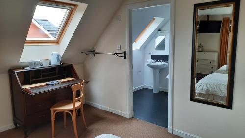 a room with a desk and a mirror and a bed at Bed-and-Bread in Blairgowrie