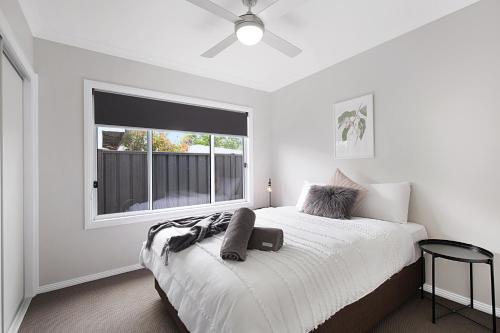 a white bedroom with a bed and a window at Milawa Vineyard Views - Guesthouse 2 in Milawa