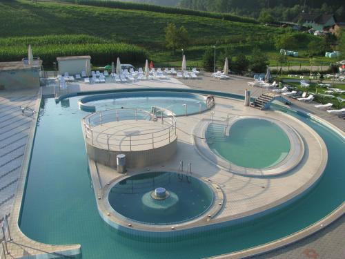 a large pool with two swimming pools in a resort at Urlaub für die Seele - Erholung Pur in der Natur - Ferienhaus mit Infrarotkabine & RELAX-Raum in Rucmanci